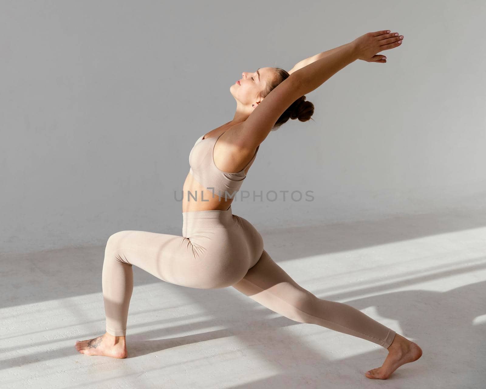 full shot woman stretching indoors