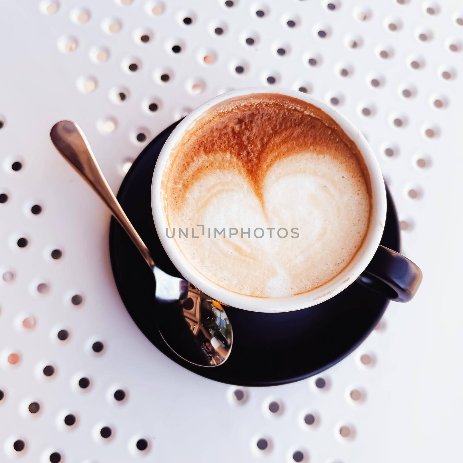 Cup of cappuccino in cafeteria by Anneleven