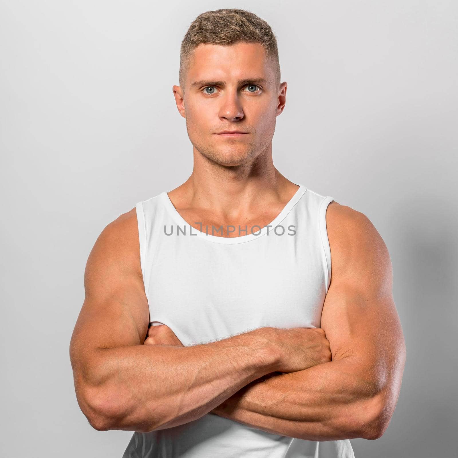 front view fit man posing while wearing tank top with crossed arms by Zahard