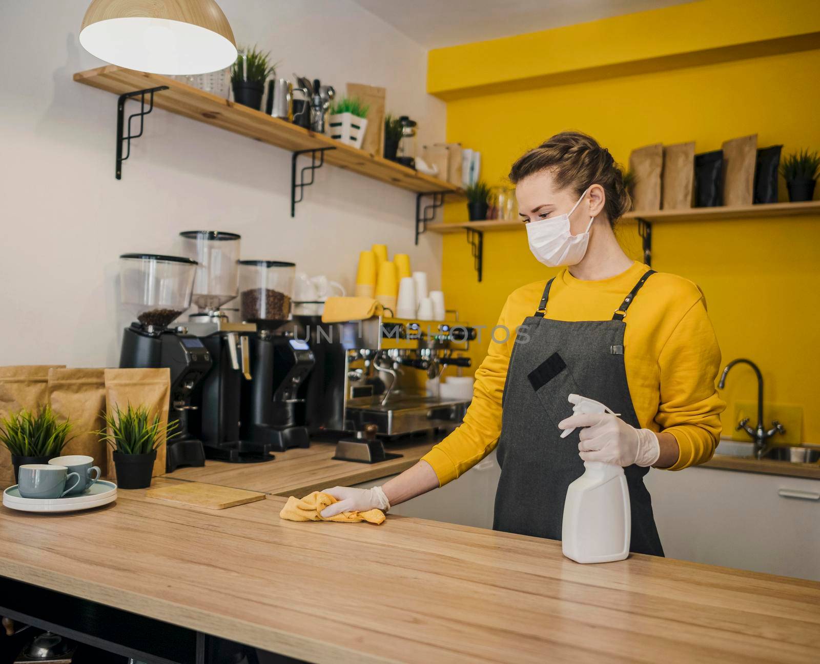 female barista cleaning surface by Zahard