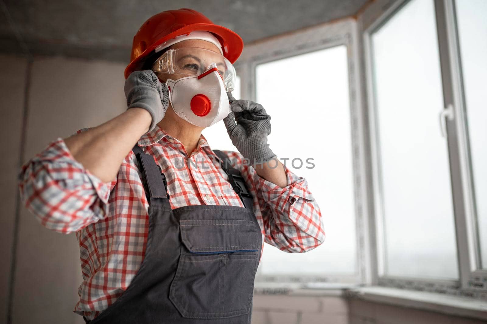 female construction worker with helmet headphones wearing face mask by Zahard