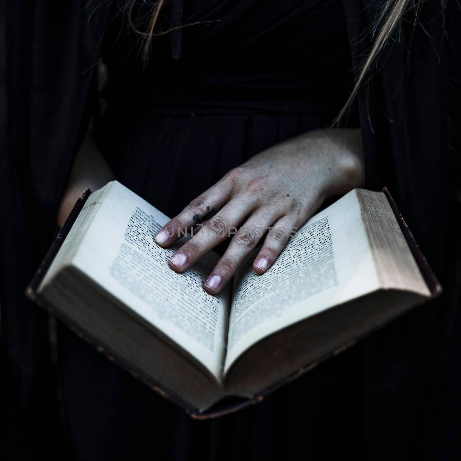 hands woman black clothes holding opened book by Zahard