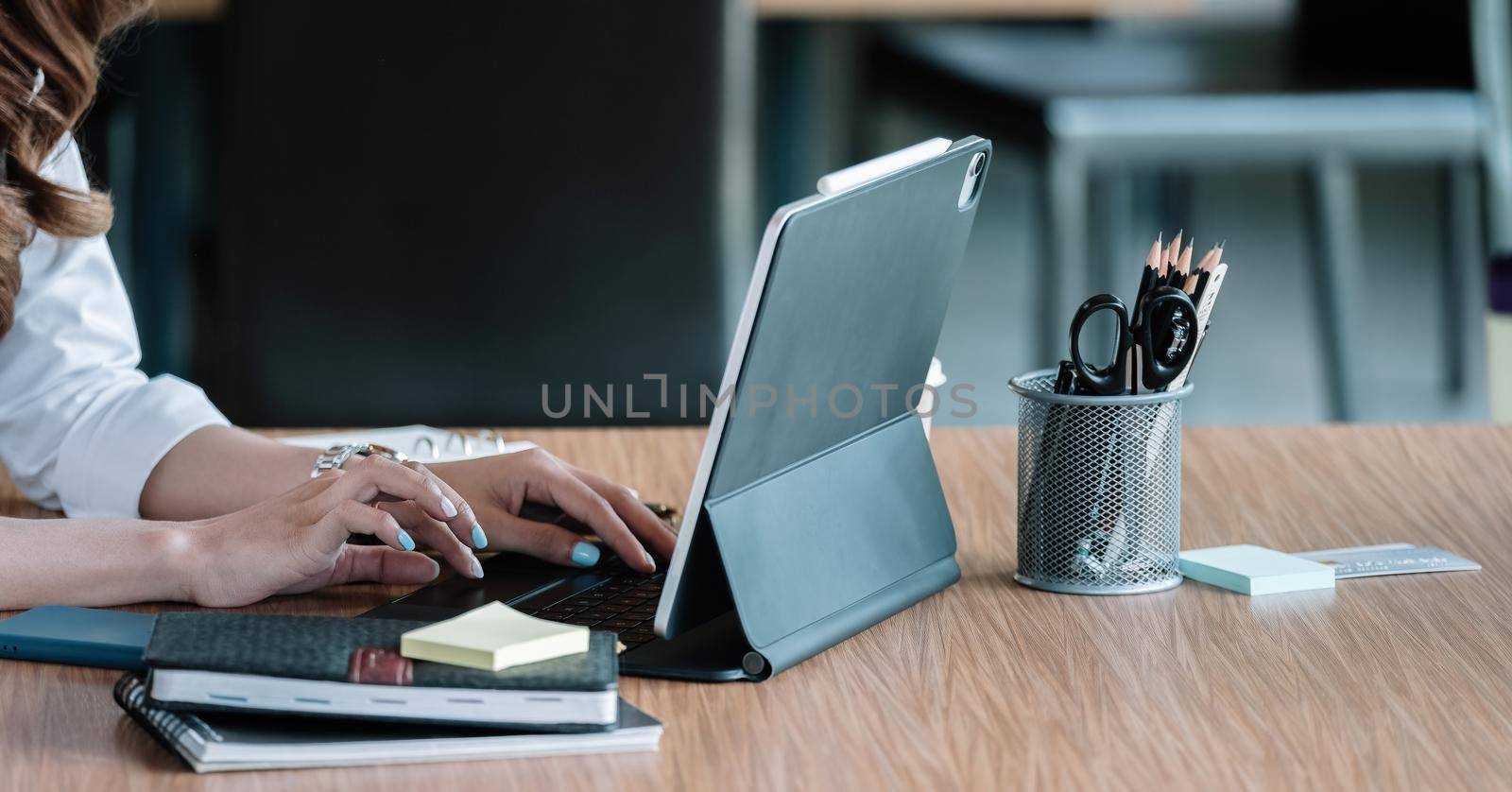 Close up hand of business woman typing keyboard on digital tablet of laptop computer.