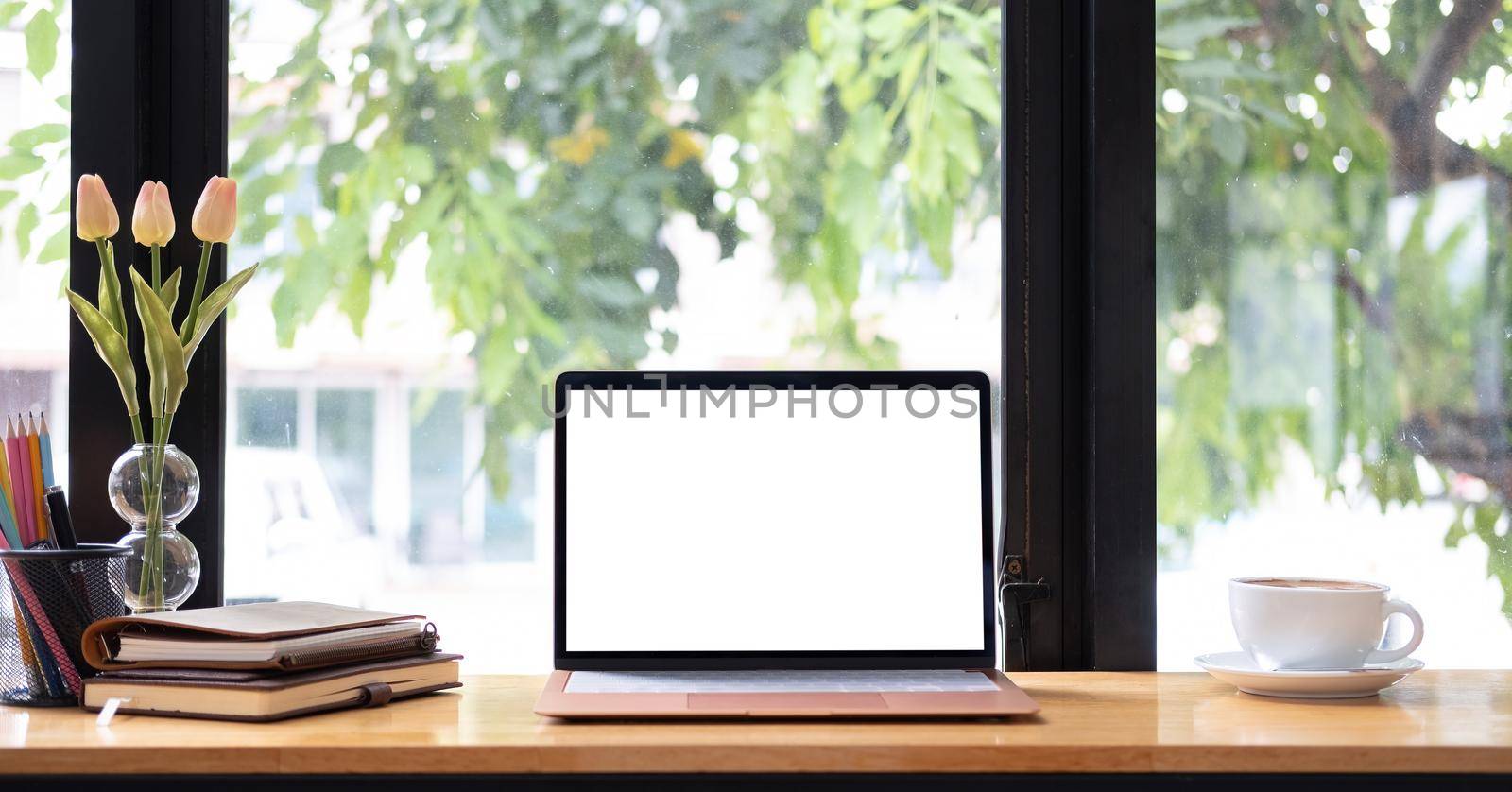 Laptop or notebook with blank screen on wood table in blurry background with house or office modern ,nature bokeh