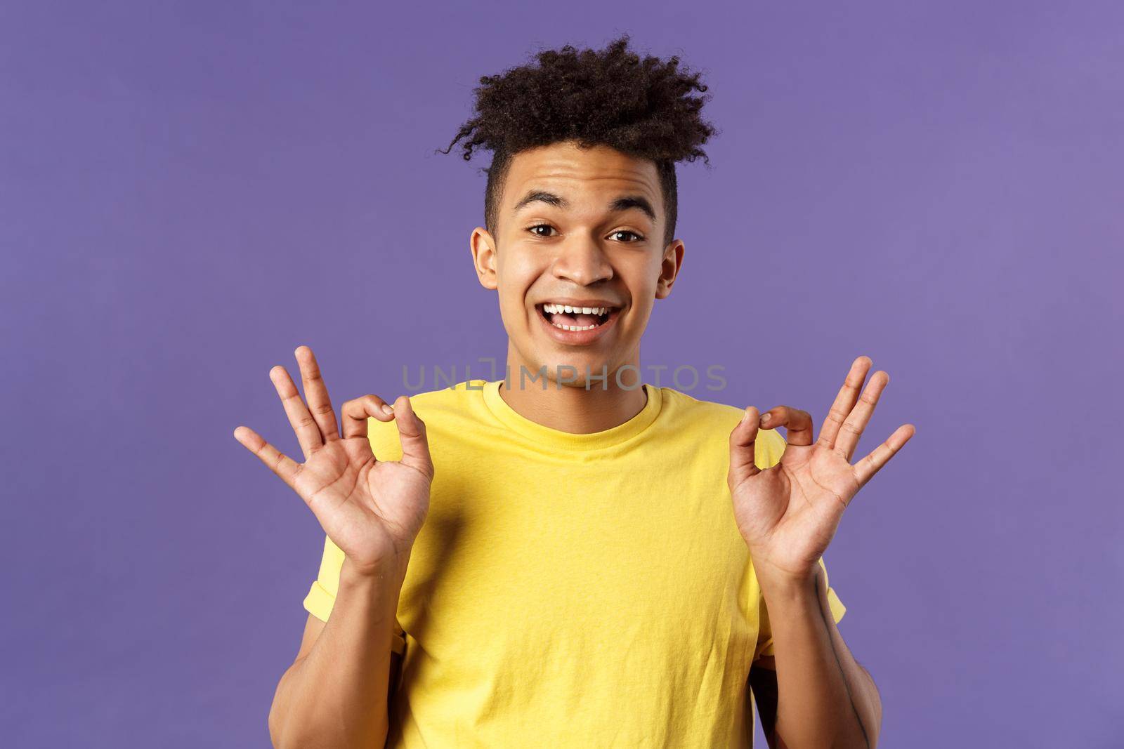 Close-up portrait of upbeat, relaxed young hipster guy with dreads assuring all good, everything be okay, show OK gesture and smiling, no problem guarantee best quality, purple background by Benzoix