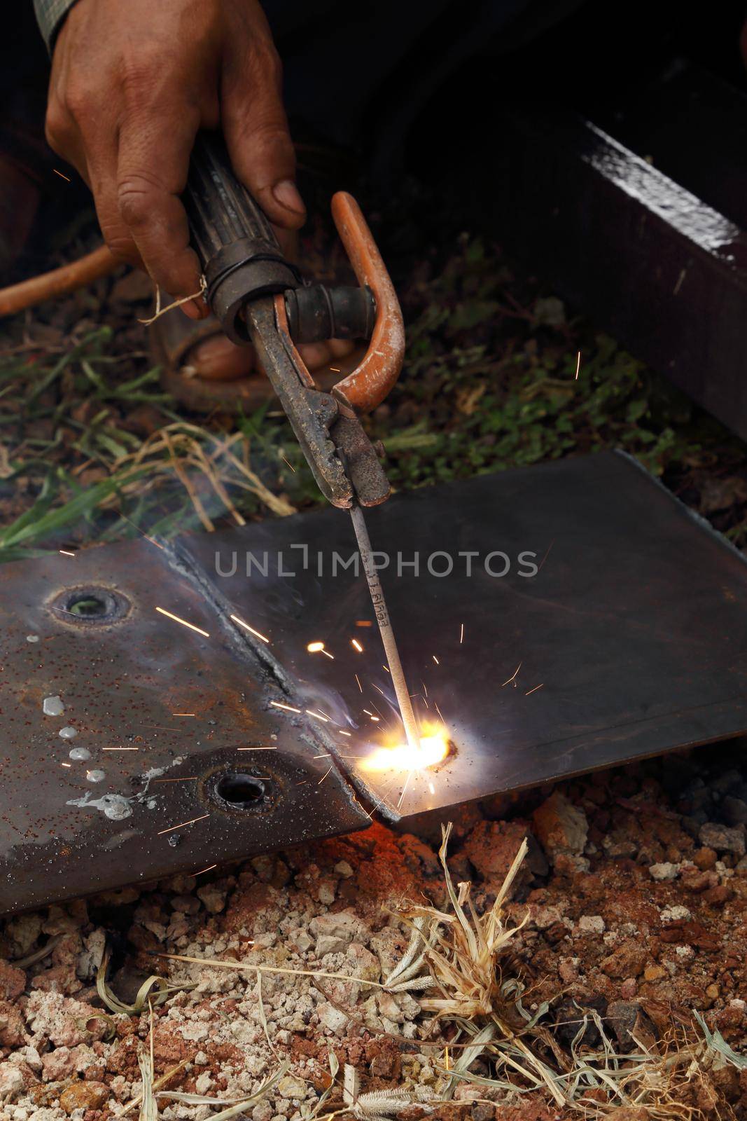 worker use electric welding for cutting hole and drill metal plate