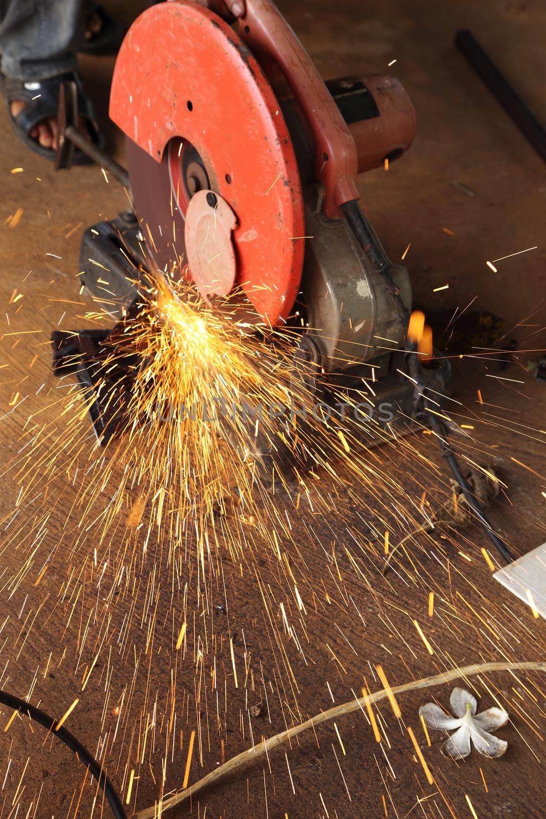 Worker cutting metal and spark with cutting machine