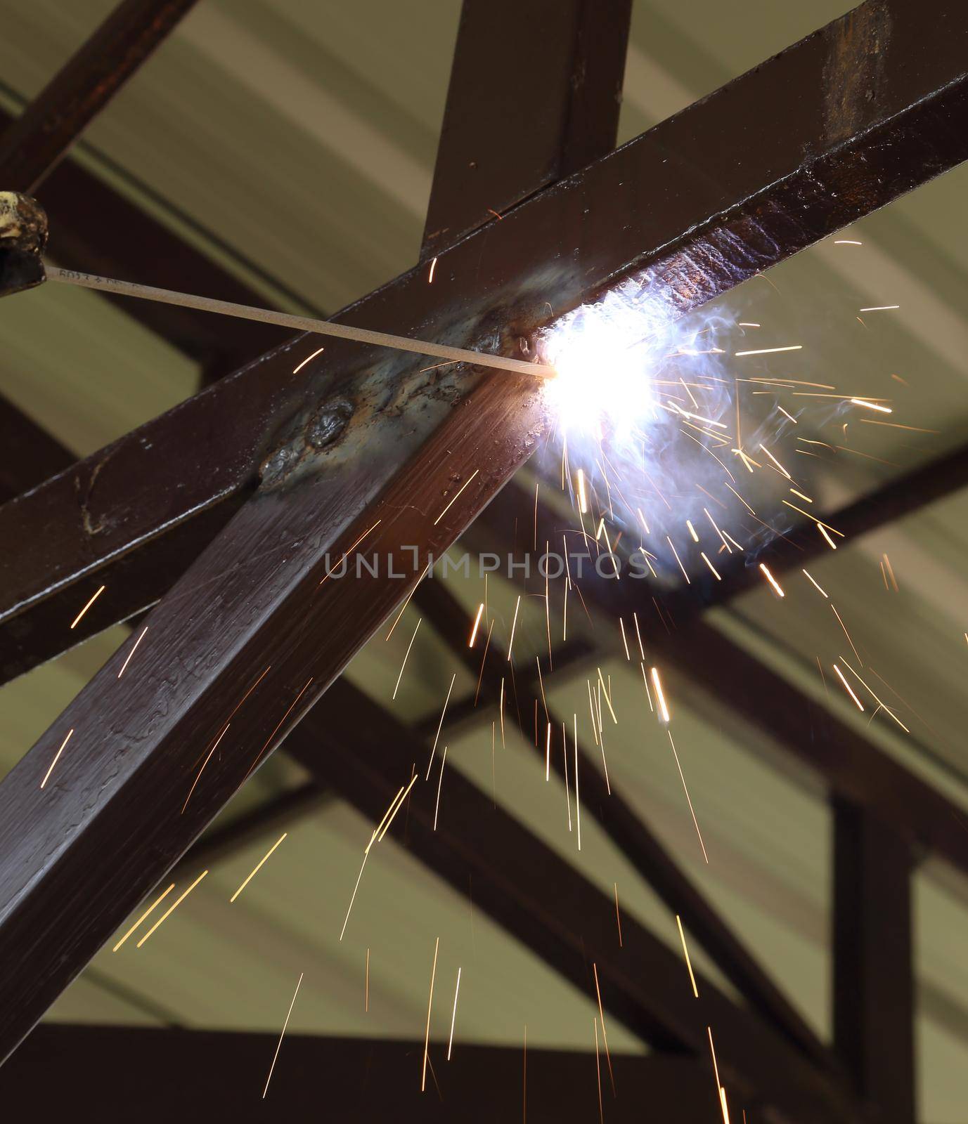 worker use electric welding connecting construction metal