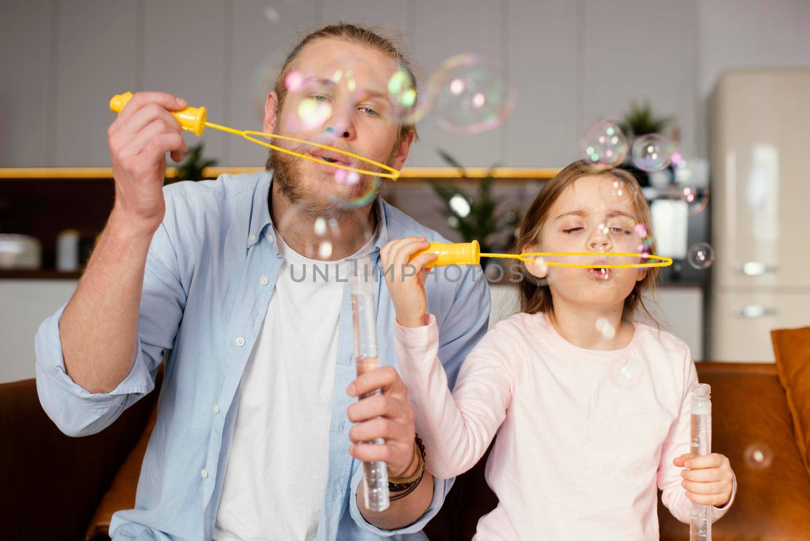 front view father daughter playing with soap bubbles