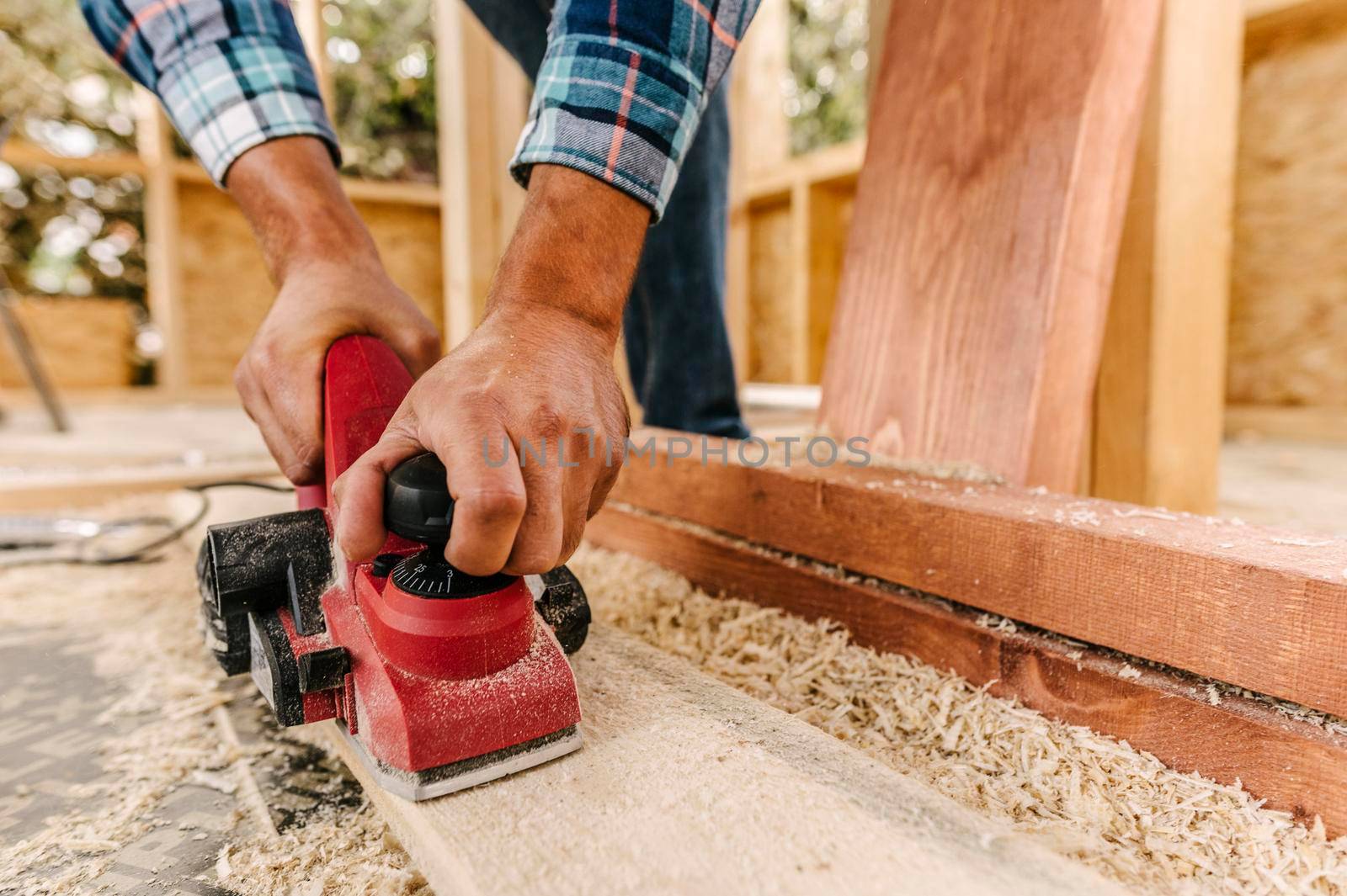 construction worker sanding down wood piece