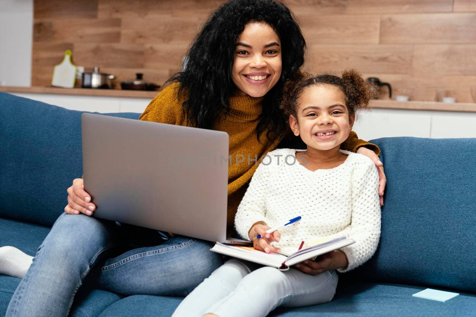 smiley teenage girl helping little sister with online school laptop by Zahard