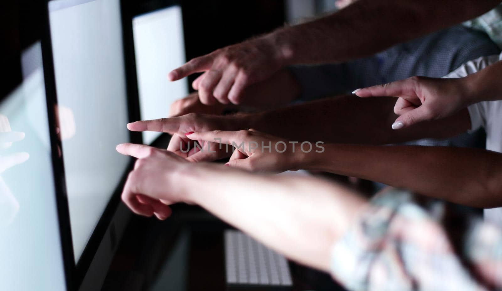 business team is pointing to the monitors of their computers.the concept of teamwork