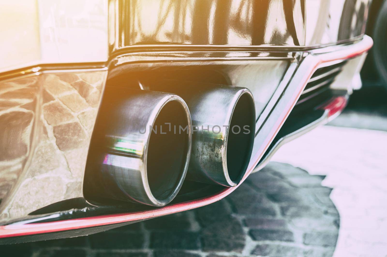 Close up of a car dual exhaust pipe in sunlight by cla78