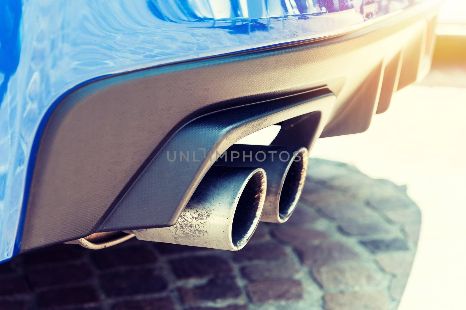 Close up of a car dual exhaust pipe in sunlight background