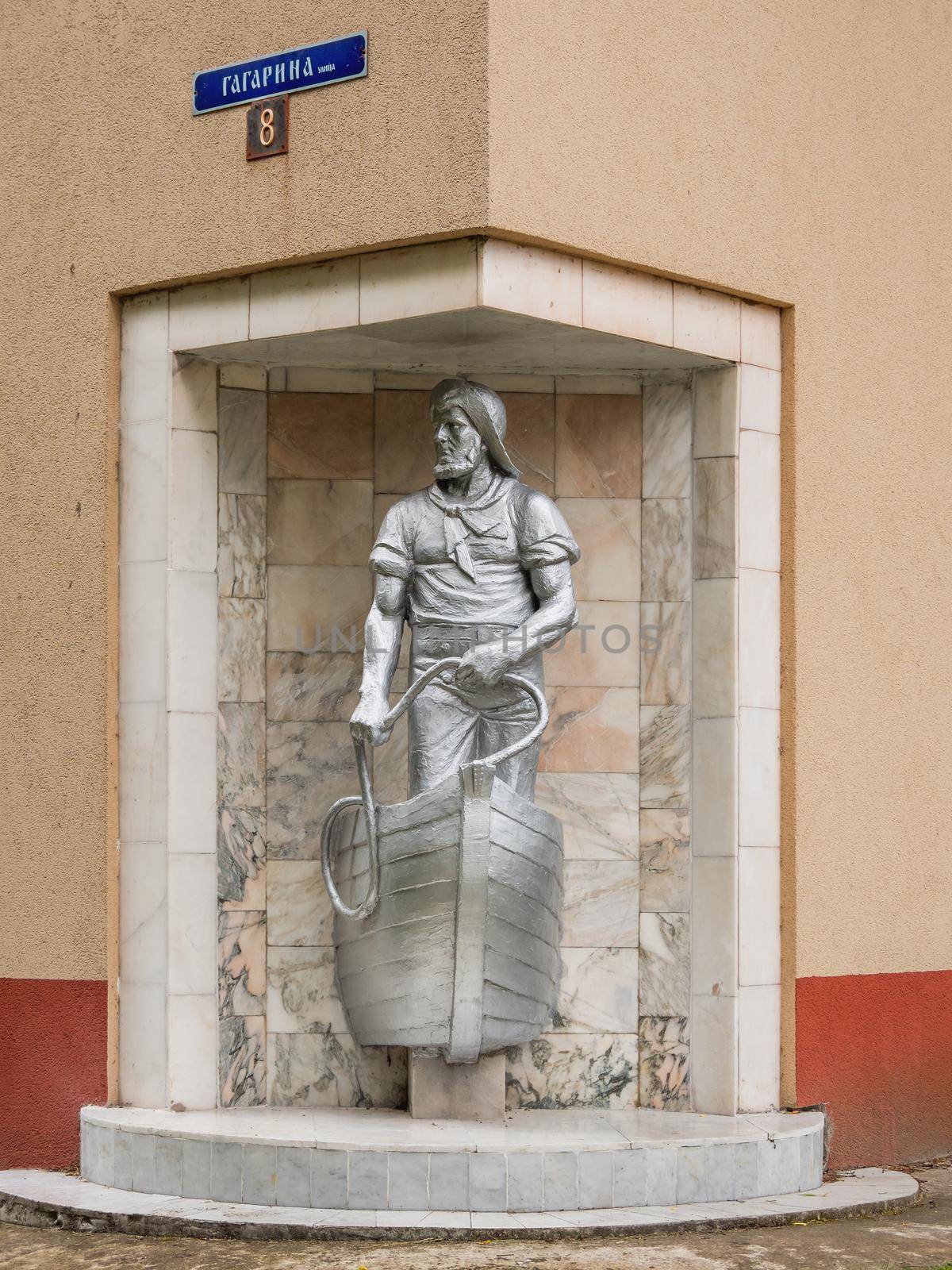 SVETLOGORSK, RUSSIA - July 21, 2019. Old monument dedicated to fisherman built into corner of apartment building. by aksenovko