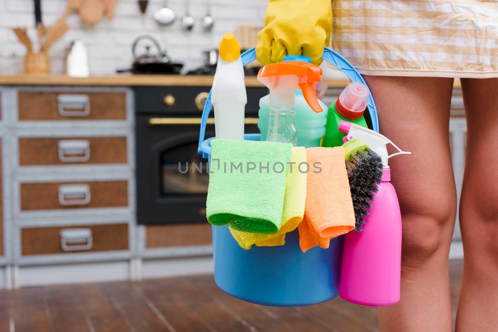 female janitor holding cleaning accessories bucket standing kitchen