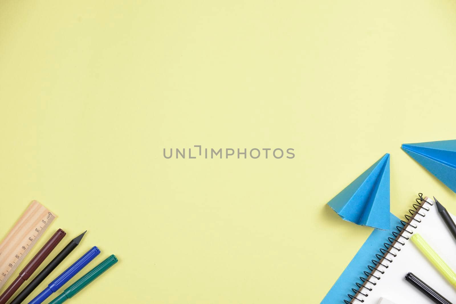 folded blue papers with office stationeries against yellow backdrop with space writing text by Zahard