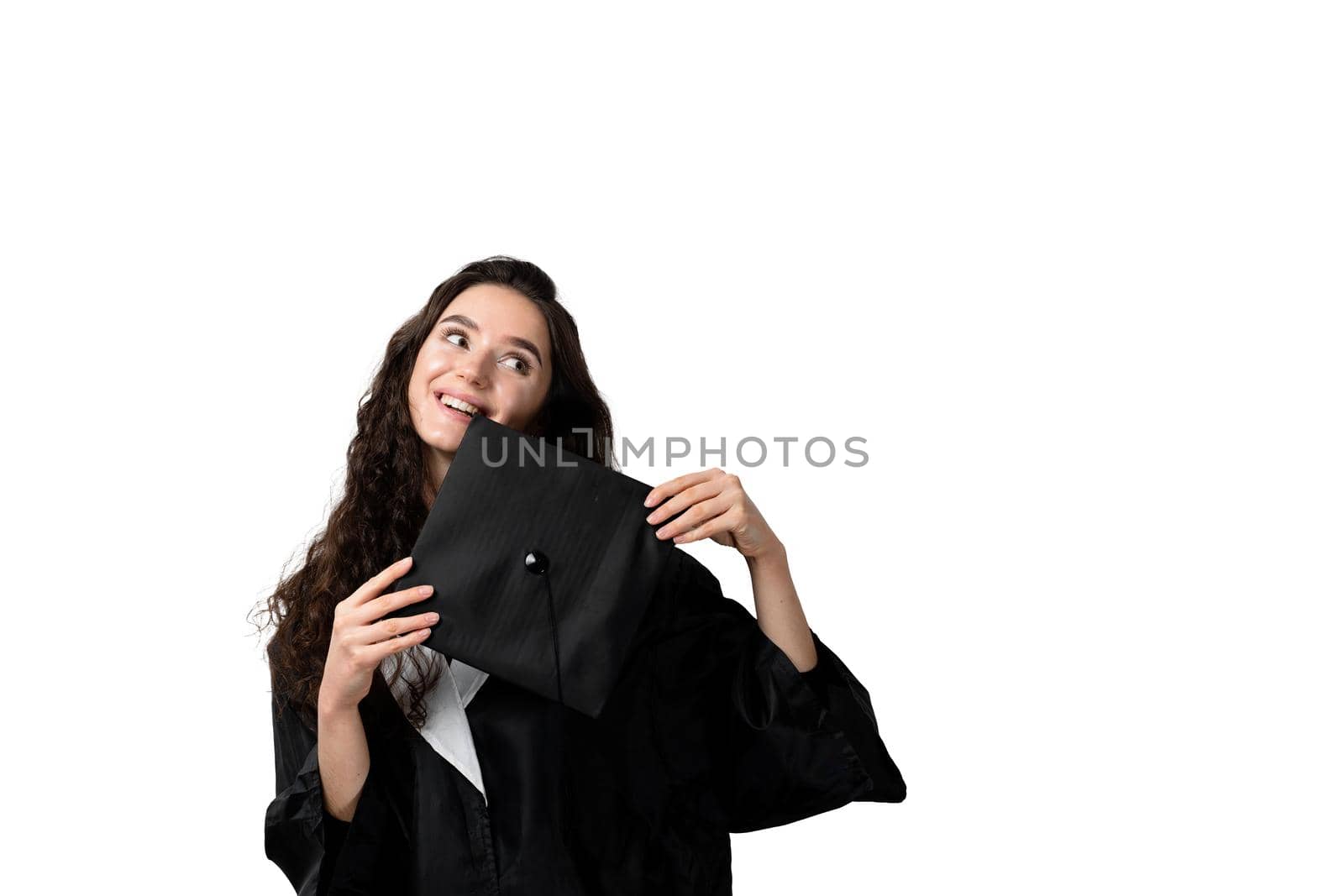 Graduate girl with master degree in black graduation gown and cap on white background. Distance learning online. Study at home. Graduation from college.
