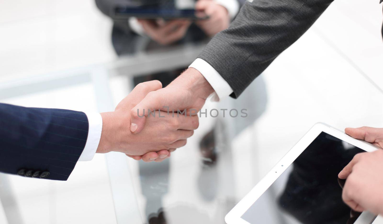 Men shaking hands with smile at office with their coworkers. by asdf