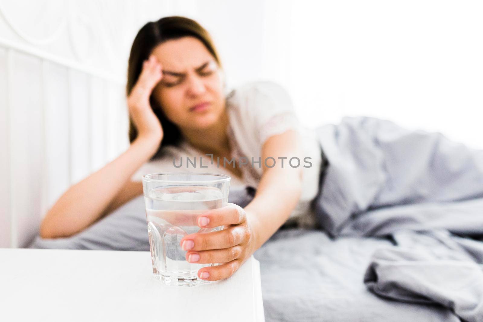 female suffering from headache taking glass water by Zahard