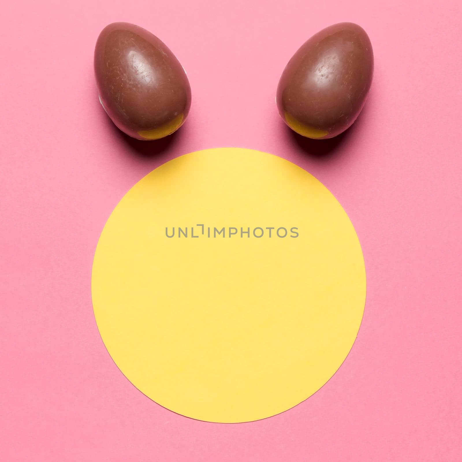 easter eggs like bunny ear s round paper blank frame against pink backdrop by Zahard