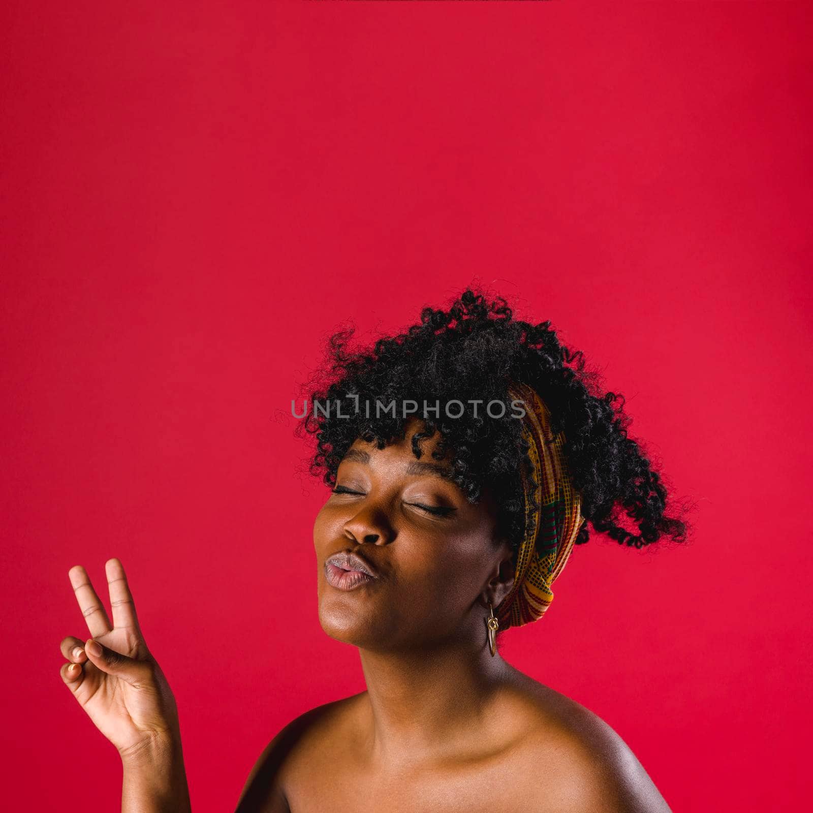 attractive nude african young woman showing peace sign studio with bright background