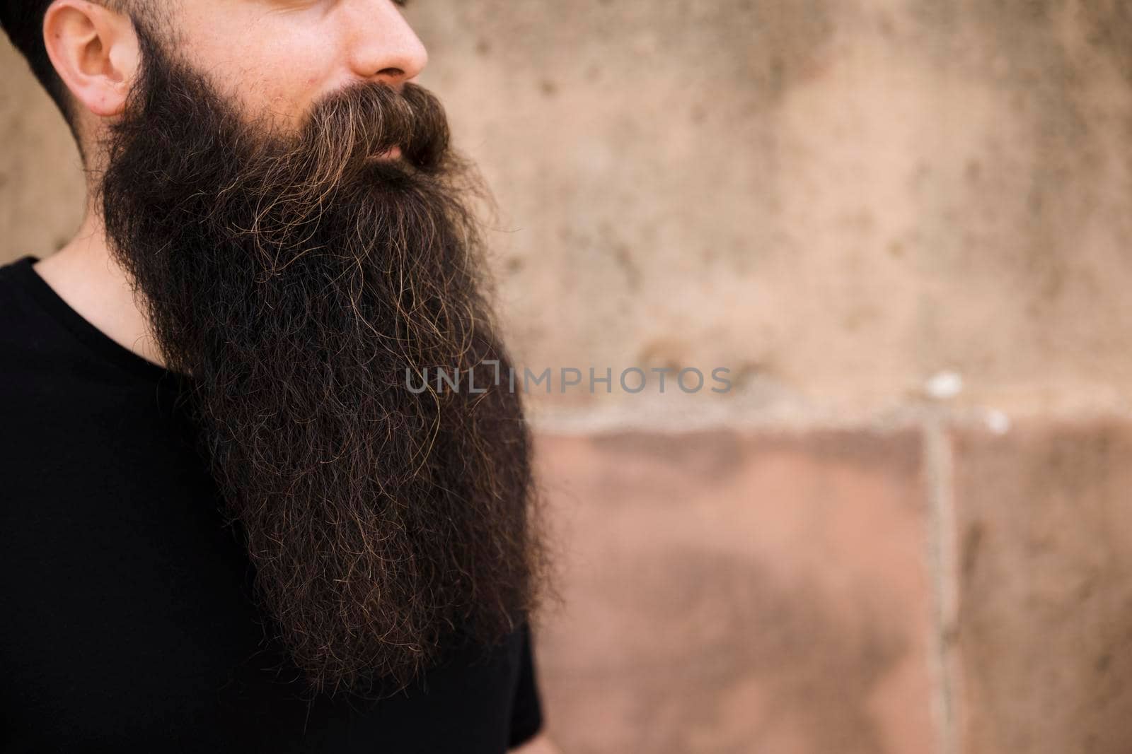 close up bearded young man against wall by Zahard