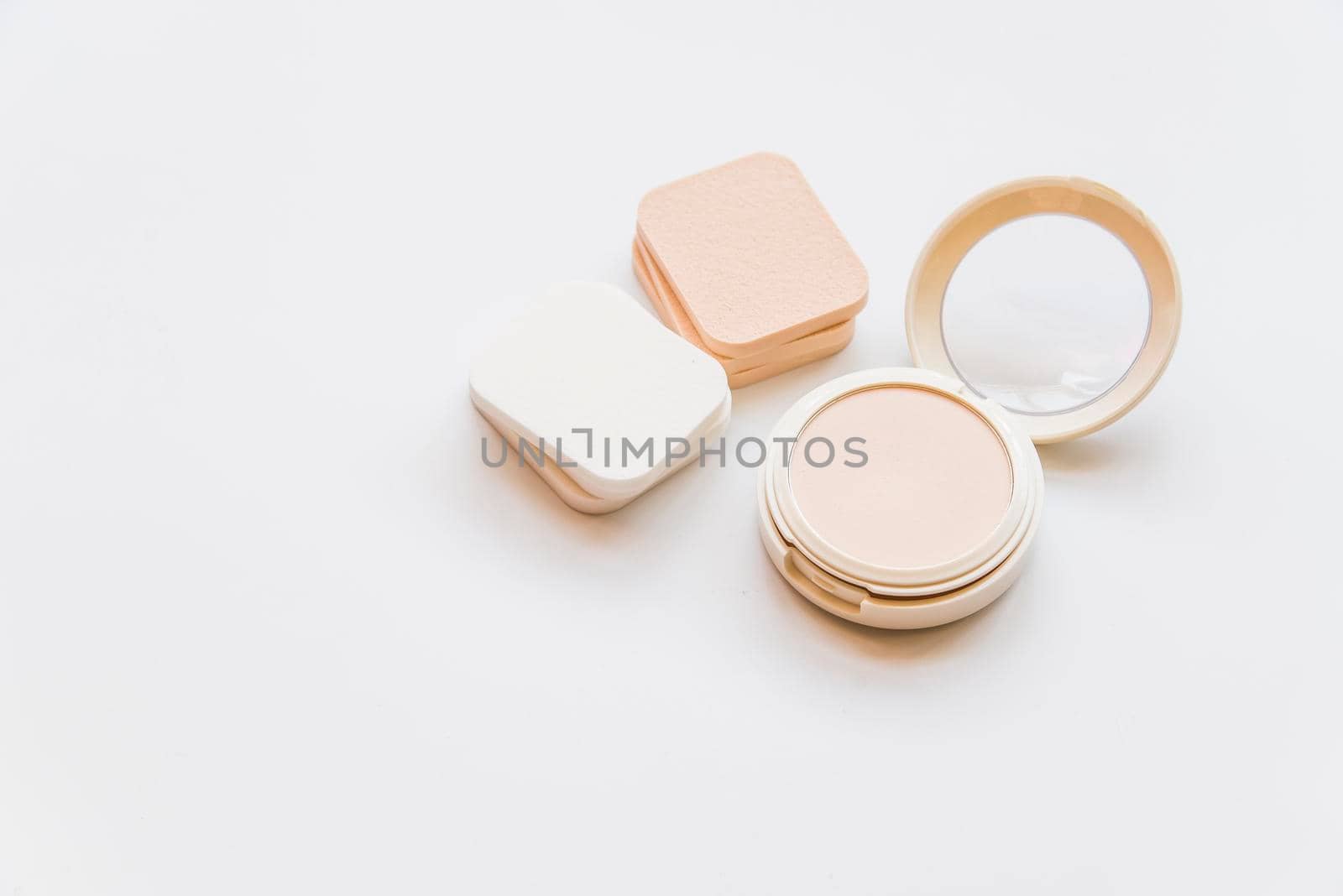 close up cosmetic realistic plastic compact powder with sponges white backdrop by Zahard