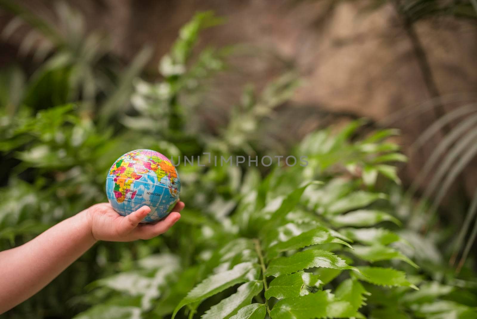 close up boy s hand holding inflatable globe ball by Zahard