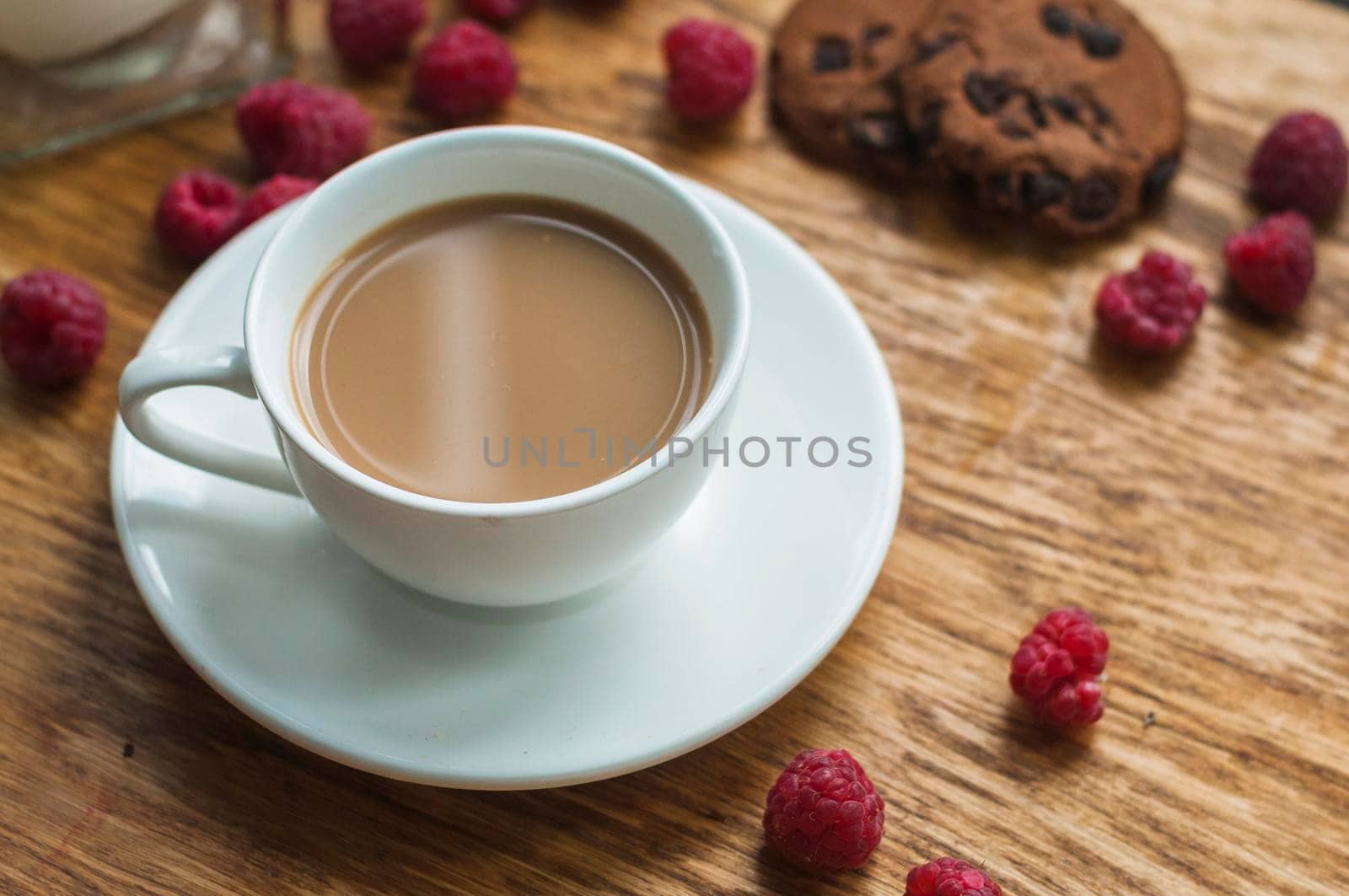white cup coffee with chocolate cookies raspberries wooden background by Zahard