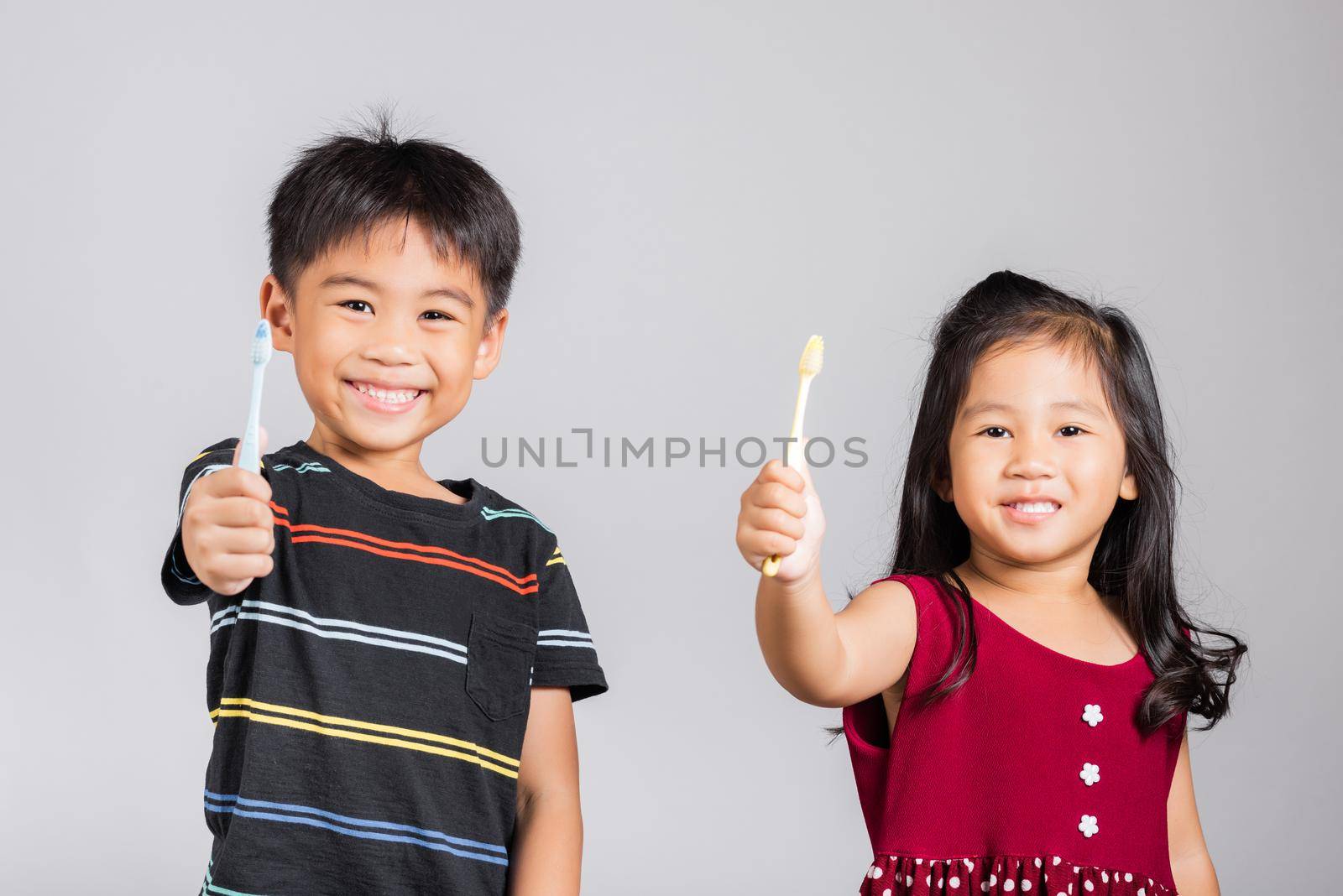 Little cute kid boy and girl 3-6 years old show brush teeth and smile in studio shot isolated by Sorapop