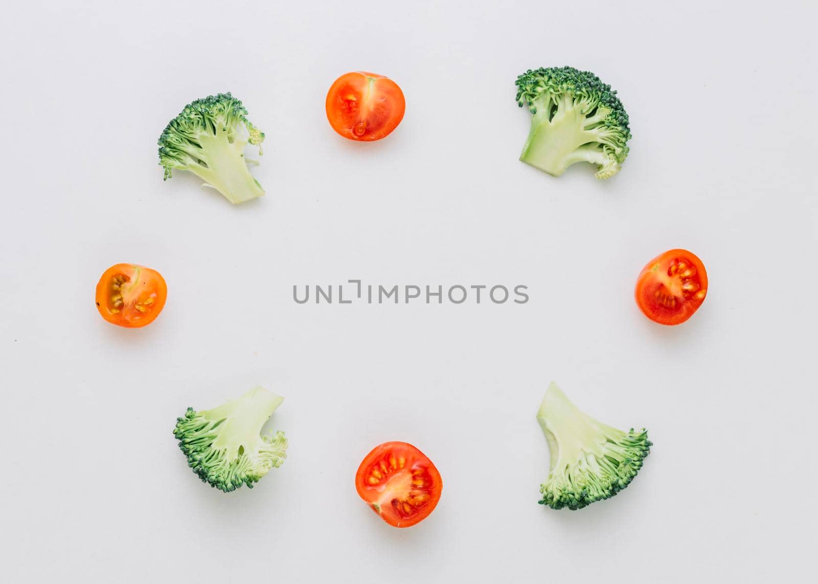 arranged halved broccoli cherry tomatoes circular frame isolated white background by Zahard