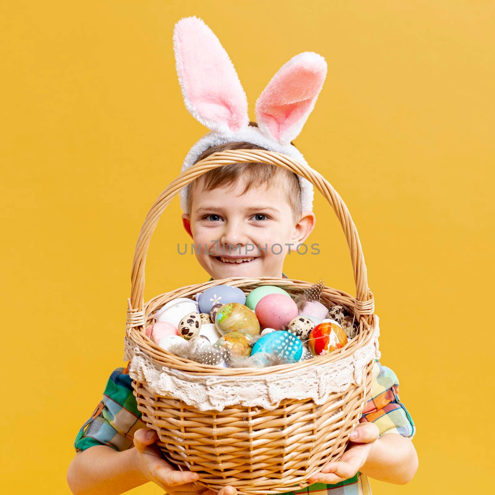 little boy holding basket with painted eggs