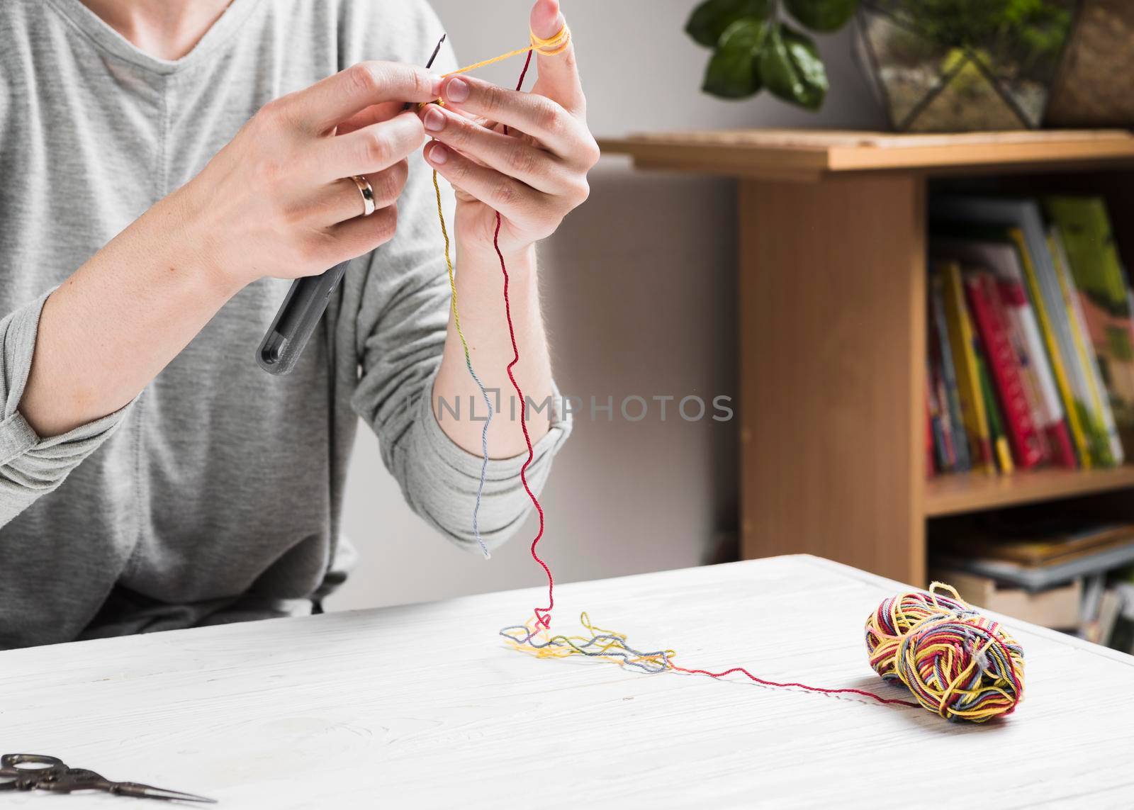 female hands knitting with colorful thread