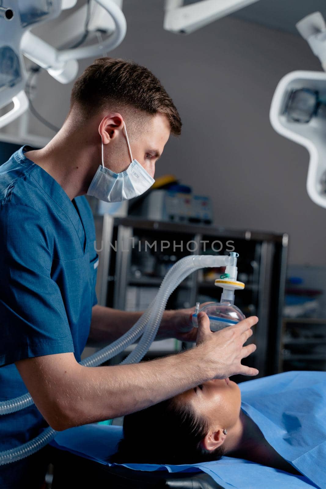 Anesthesiologist making ingalation anesthesia for patient. Doctor puts a mask on the patient before starting operation.