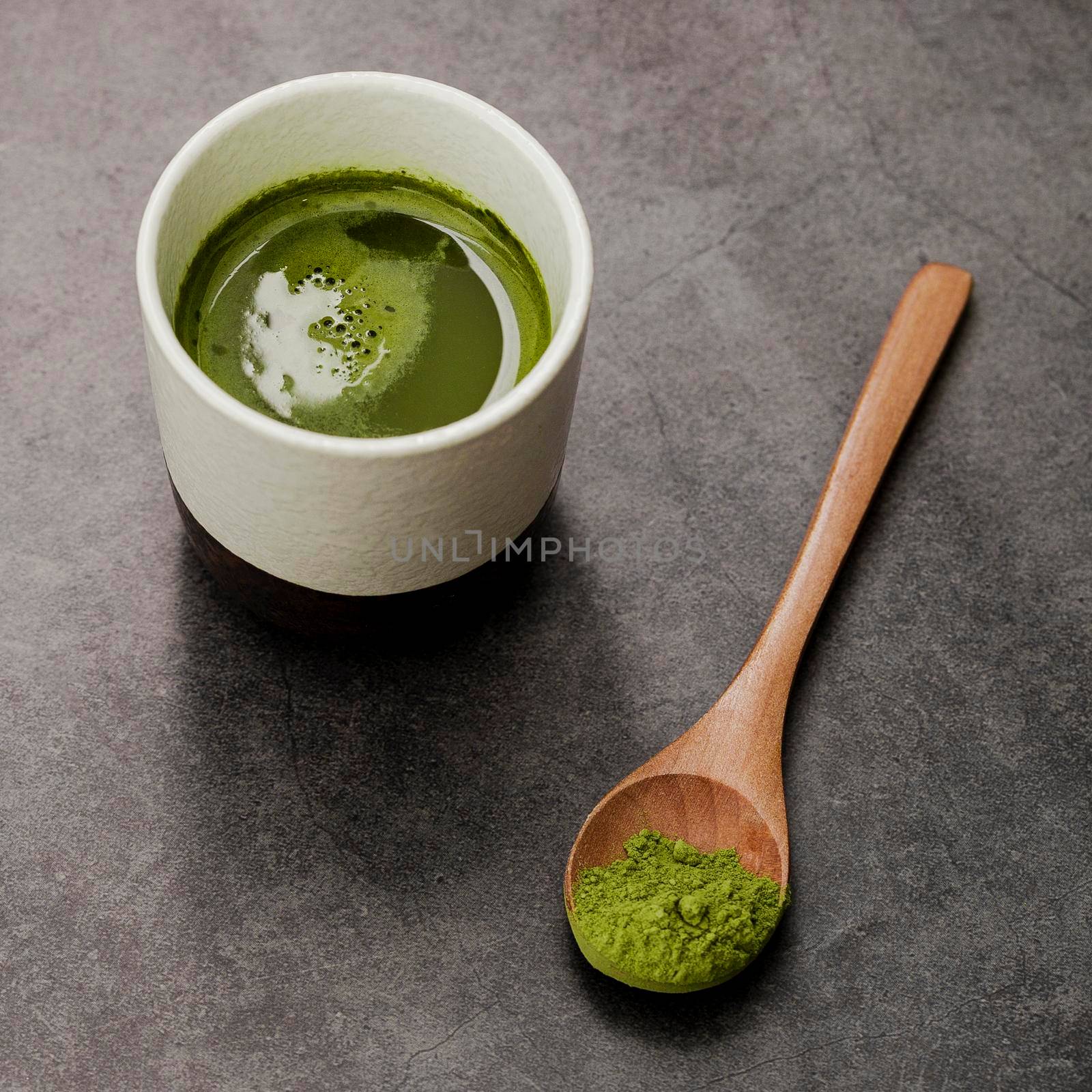 close up matcha tea cup with wooden spoon