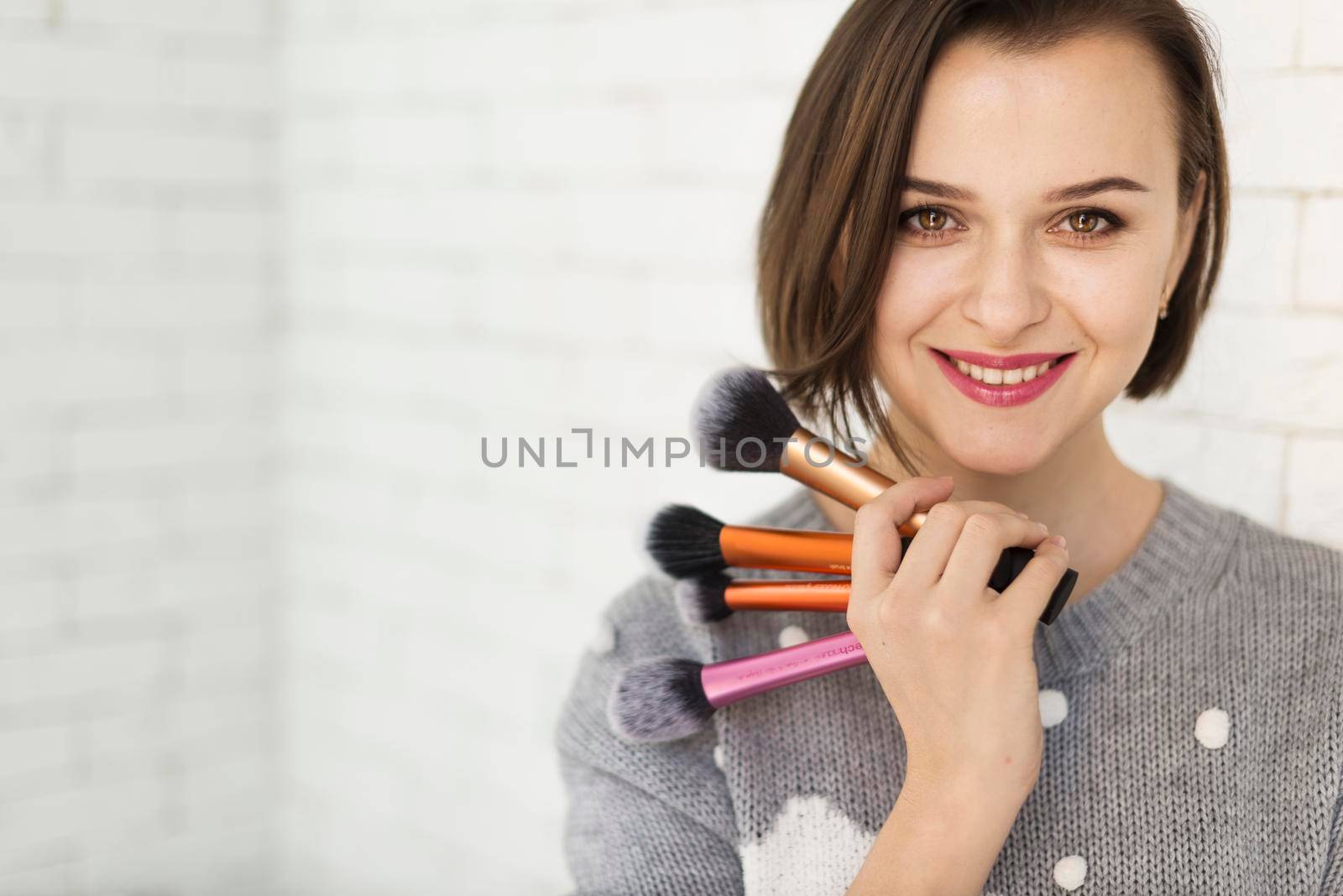 smiling woman with makeup brushes by Zahard