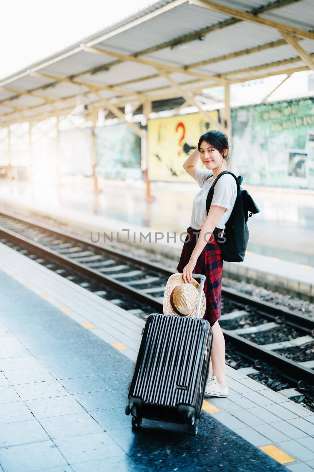 summer, relax, vacation, travel, portrait of cute Asian girl showing smile and showing joy while waiting at the train station for a summer trip. by Manastrong