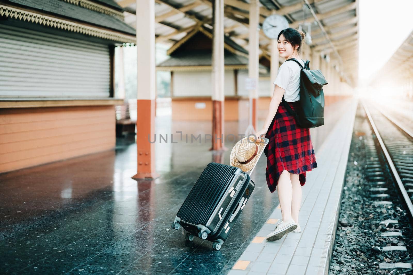 summer, relax, vacation, travel, portrait of cute Asian girl showing smile and showing joy while waiting at the train station for a summer trip. by Manastrong