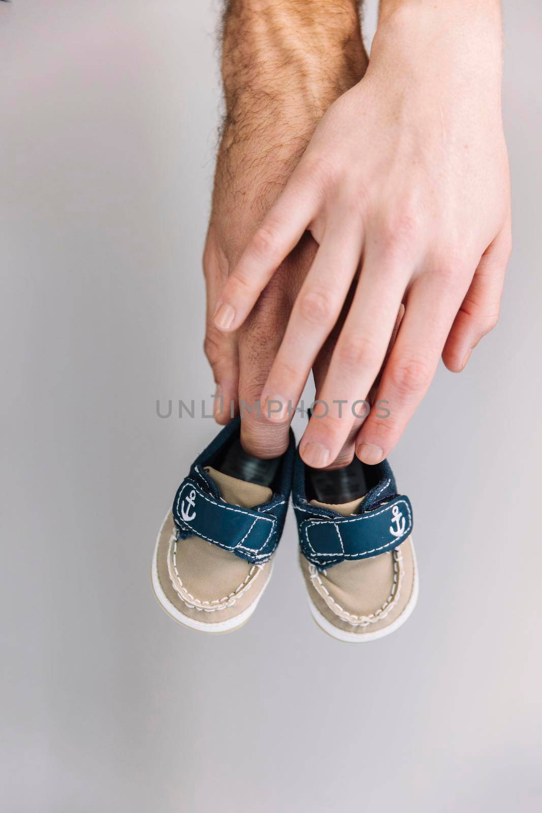 hand holding baby shoes by Zahard