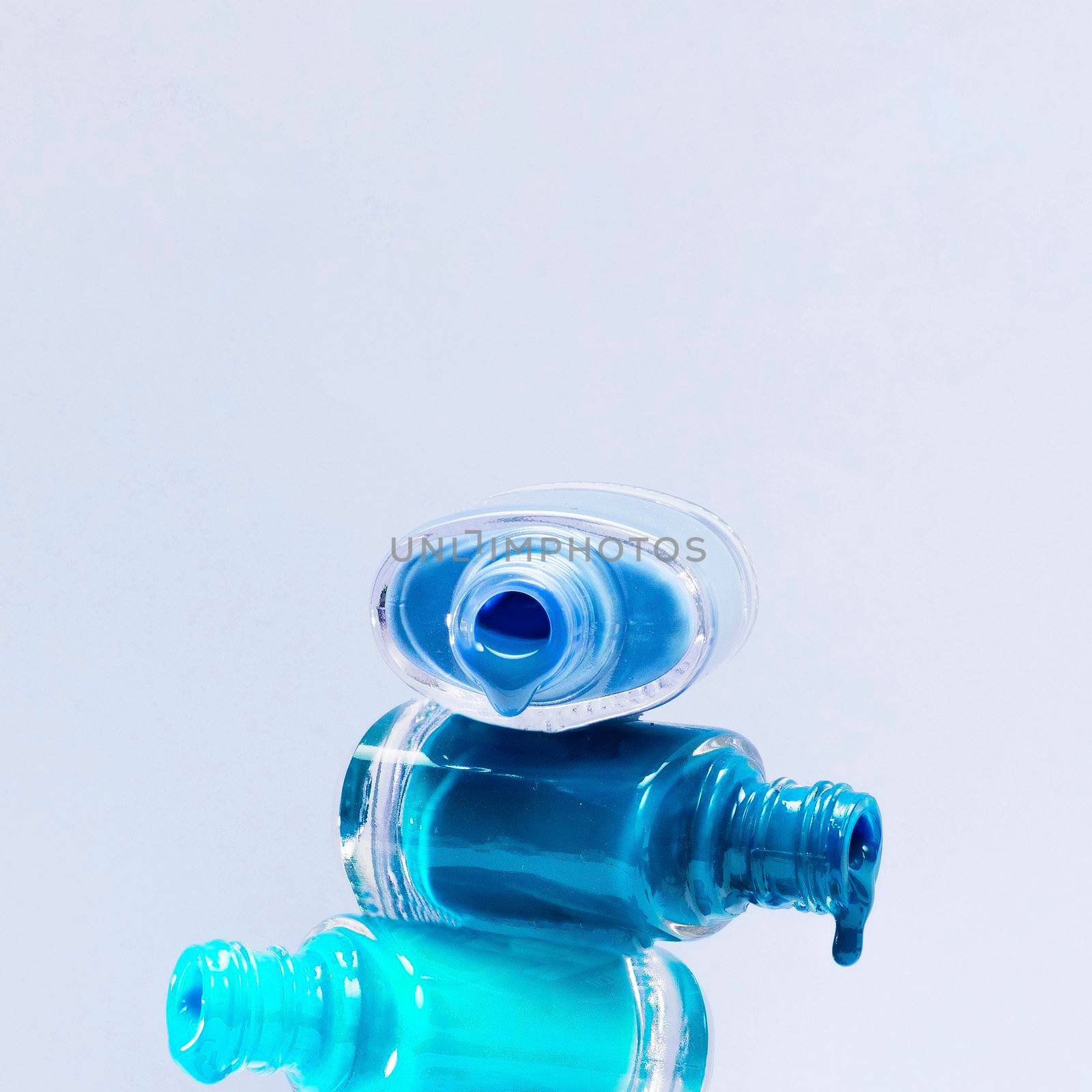 close up blue shades nail polish with stacked open bottle by Zahard