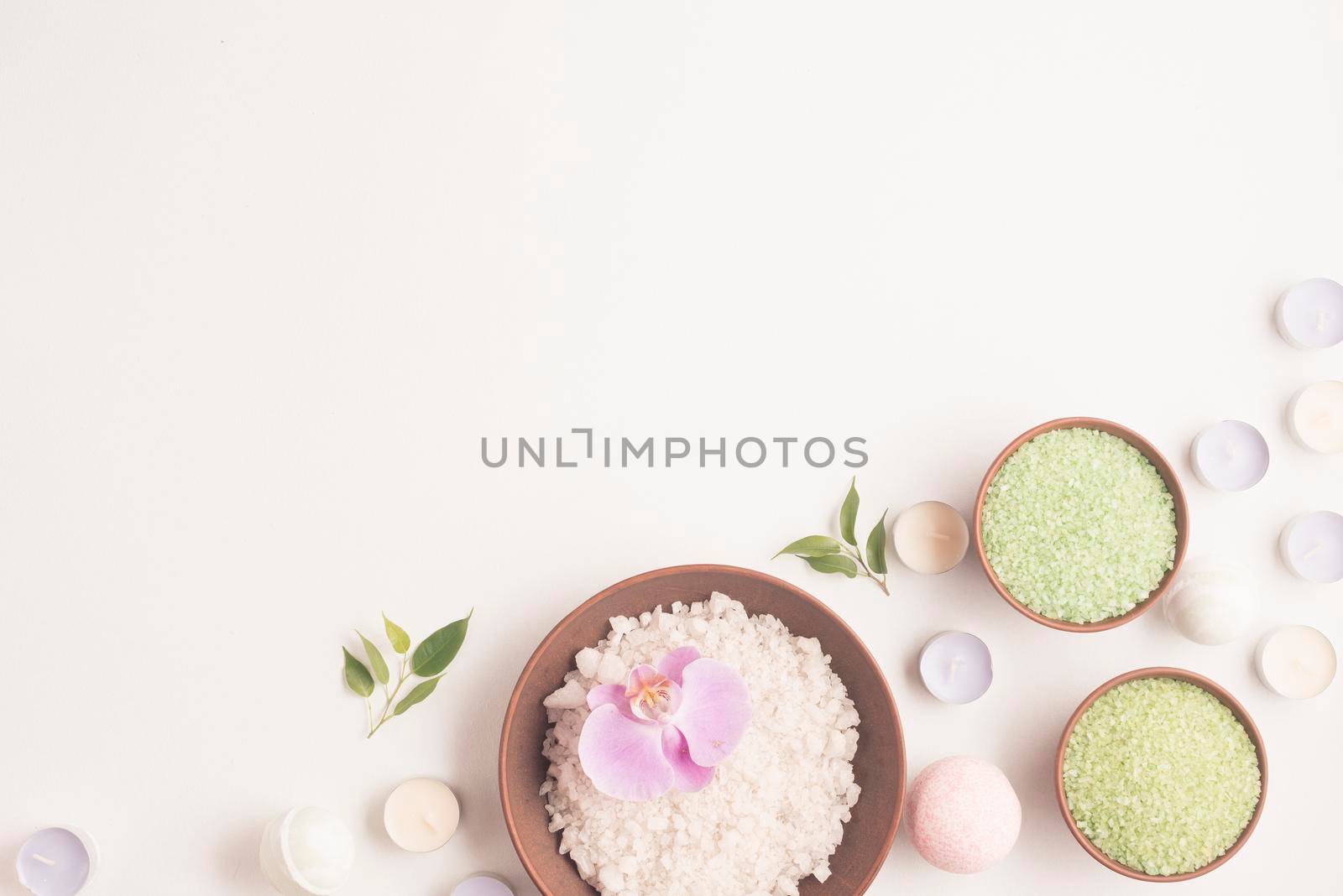 green white herbal sea salt with many small candles white backdrop by Zahard