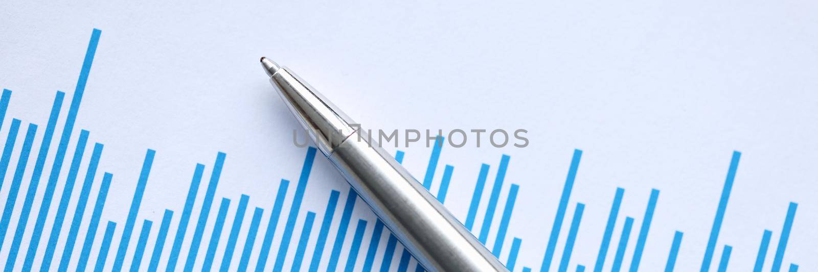 Ballpoint pen lying on document with graph closeup. Profit growth in business concept