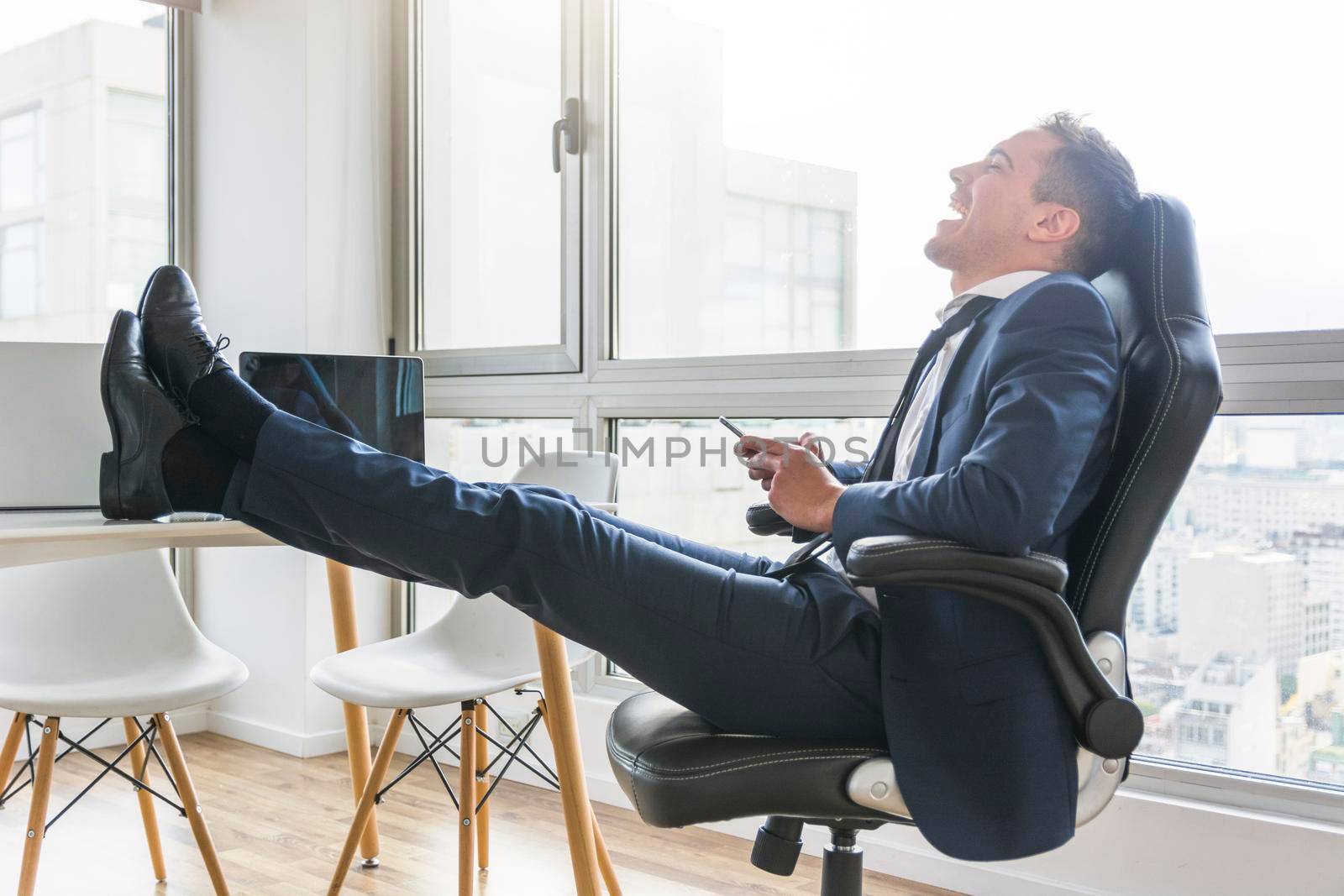 happy businessman sitting chair workplace using mobile by Zahard