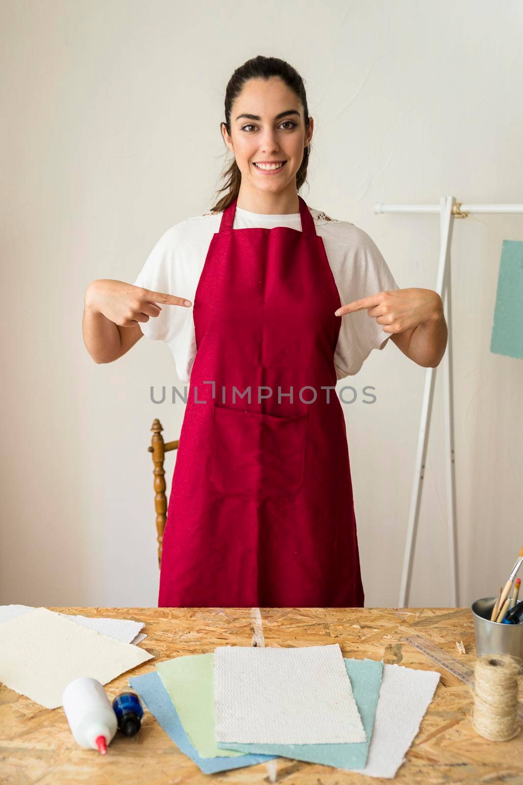 portrait smiling young woman pointing fingers her red apron by Zahard