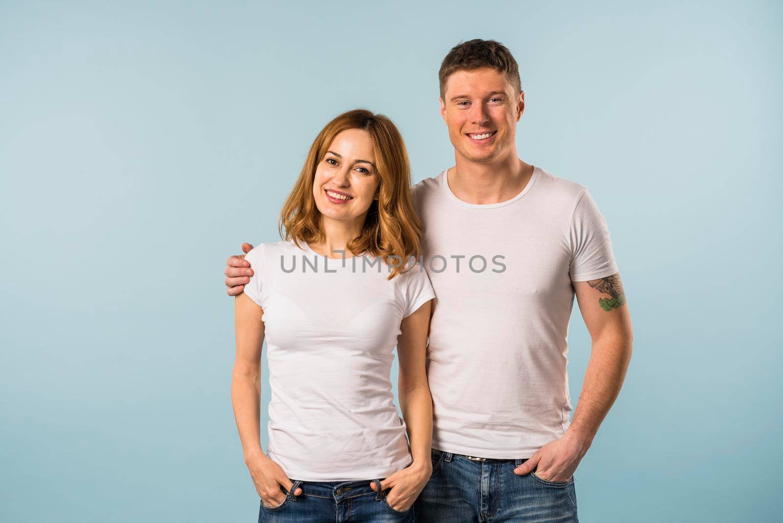 portrait smiling young couple against blue background by Zahard