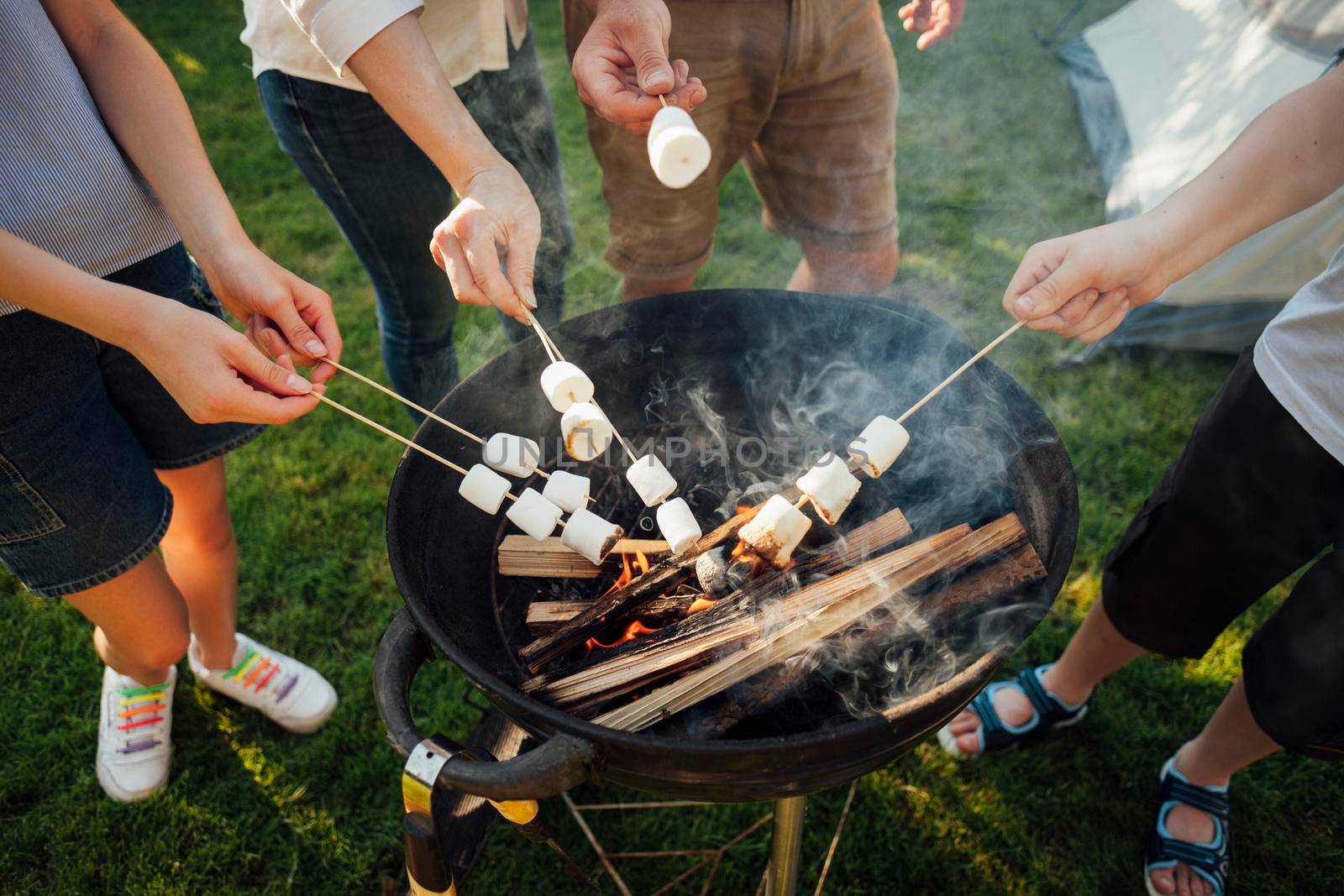 elevated view hands roasting marshmallow barbecue fire