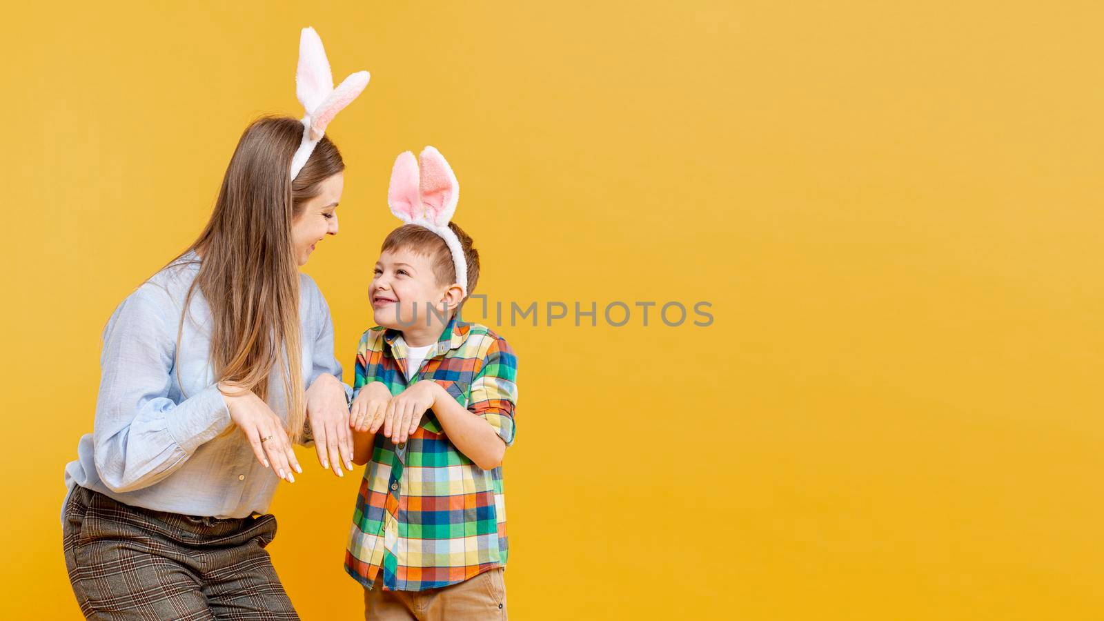 mother son imitating rabbit with copy space