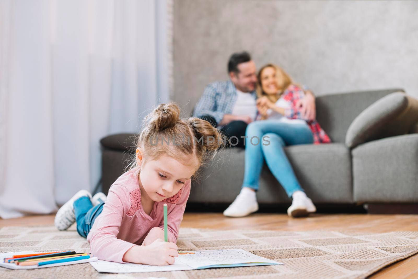 little girl drawing book lying floor while her loving parents sitting sofa by Zahard