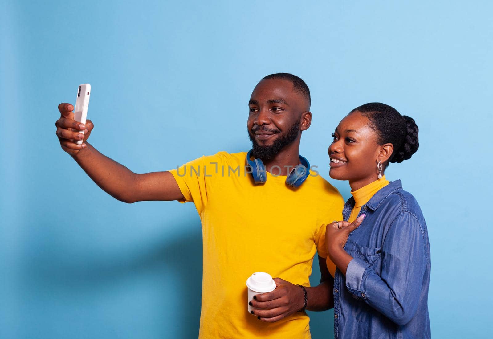 Happy couple taking selfies on smartphone in studio by DCStudio